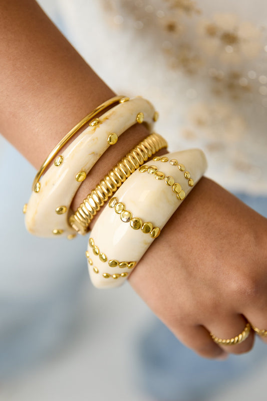 Resin bangle bracelet with studs in a striped pattern